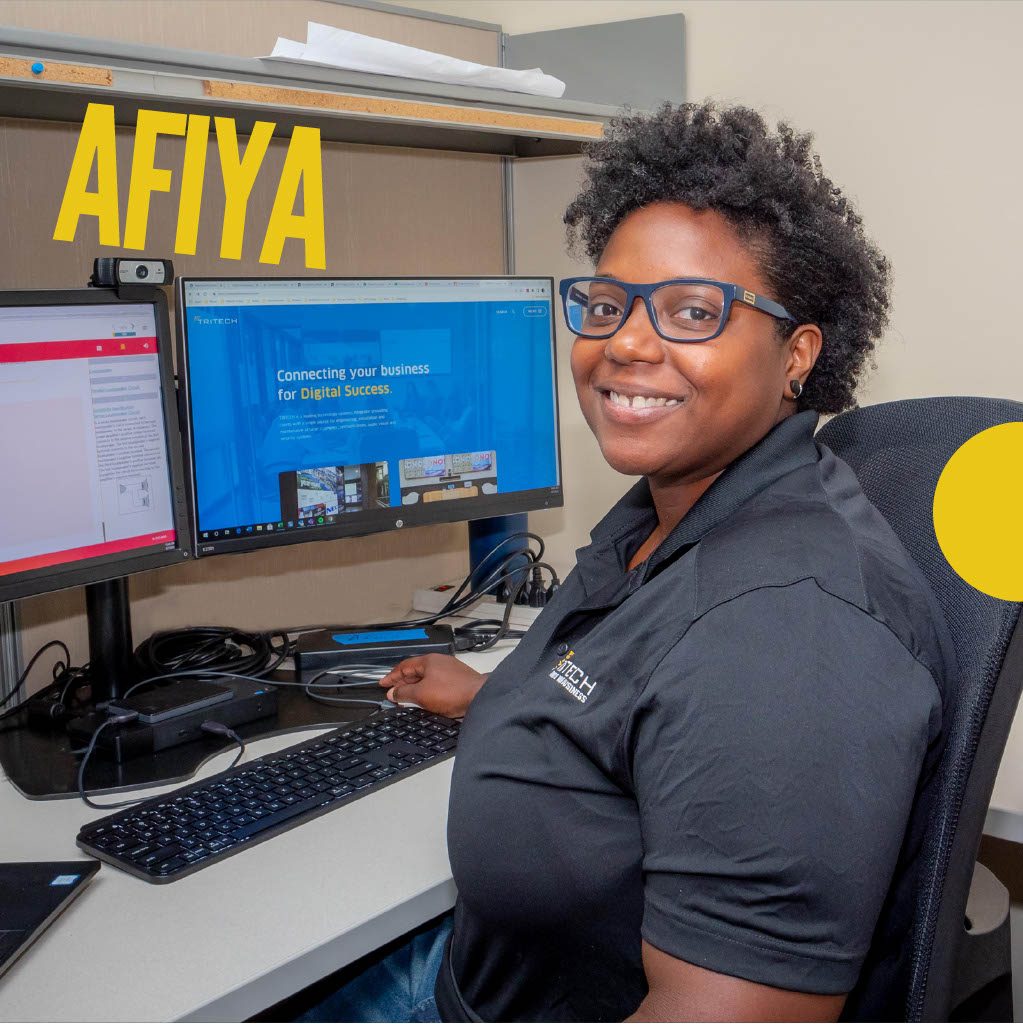 Woman sitting at computer with two monitors. Name Afiya in yellow font.